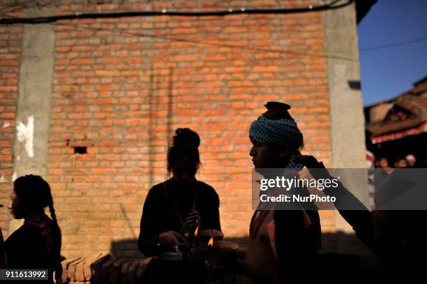 Nepalese devotee carries oil lamps on his head and shoulders during the Swasthani Brata Katha festival or Madhav Narayan Festival celebrated in...