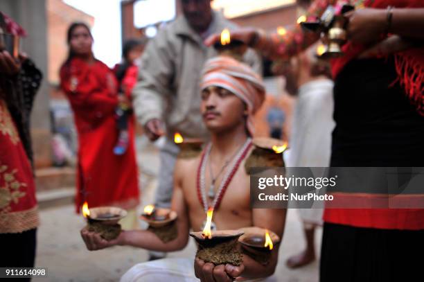 Nepalese devotee carries oil lamps on his head and shoulders during the Swasthani Brata Katha festival or Madhav Narayan Festival celebrated in...