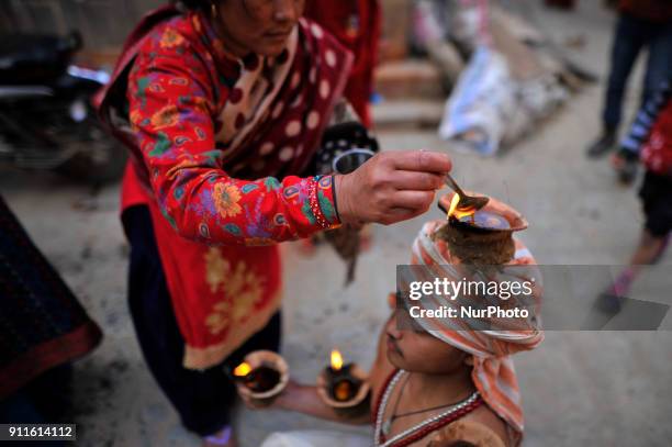 Nepalese devotee carries oil lamps on his head and shoulders during the Swasthani Brata Katha festival or Madhav Narayan Festival celebrated in...