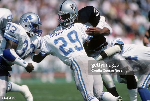 Marcus Allen of the Los Angeles Raiders runs the ball against Bruce McNorton and William Graham of the New England Patriots during the game at the...