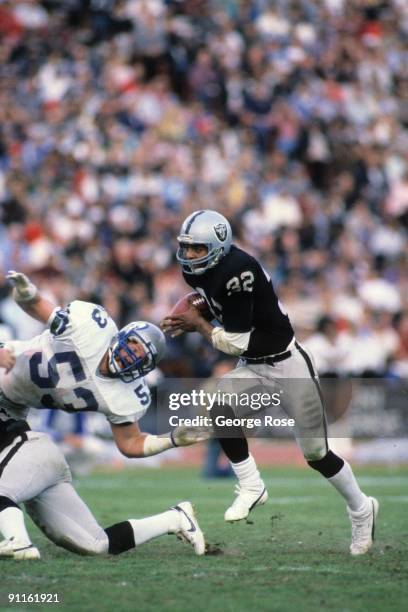 Marcus Allen of the Los Angeles Raiders runs the ball past Keith Butler of the Seattle Seahawks during the game at the Los Angeles Memorial Coliseum...