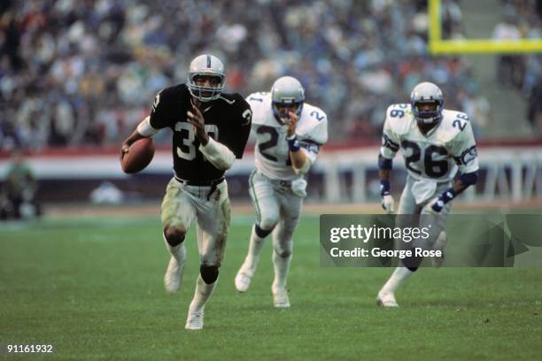 Marcus Allen of the Los Angeles Raiders runs the ball during the AFC Championship game against the Seattle Seahawks at the Los Angeles Memorial...