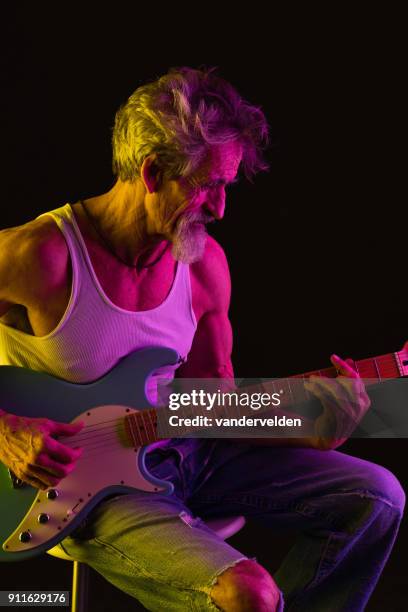 ageing rocker playing guitar - gel effect lighting stock pictures, royalty-free photos & images