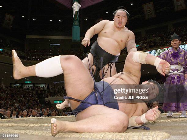 Mongolian grand champion Asashoryu throws Ozeki ranked Kotomitsuki to the ground at his 14th day bout of the Autumn Grand Sumo tournament in Tokyo on...
