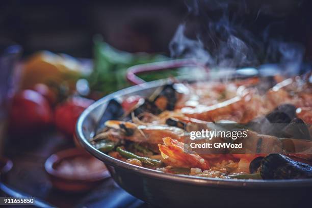 spanish seafood paella with shrimps, green beans, and paprika - paella stock pictures, royalty-free photos & images