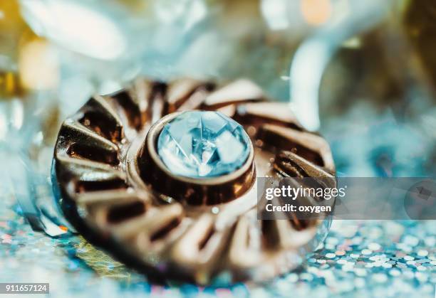 gold metall button with cristal on bokeh background - button sewing item stock-fotos und bilder