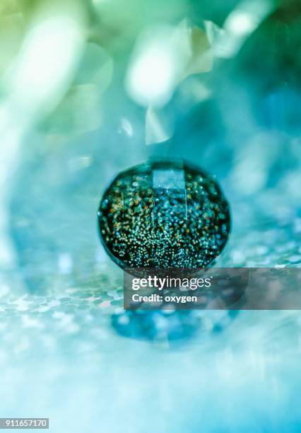 crystal button on aqua bokeh background - button sewing item stock-fotos und bilder