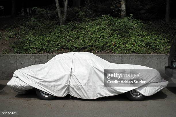 covered car - tarpaulin stock pictures, royalty-free photos & images