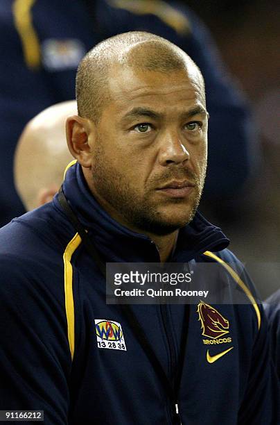 Australian cricketer Andrew Symonds watches from the Broncos bench during the second NRL Preliminary Final match between the Melbourne Storm and the...
