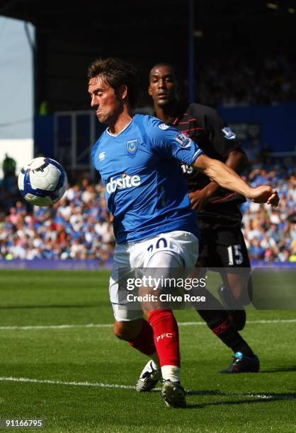 Tommy Smith of Portsmouth is challenged by Sylvain Distin of Everton during the Barclays Premier League match between Portsmouth and Everton at...