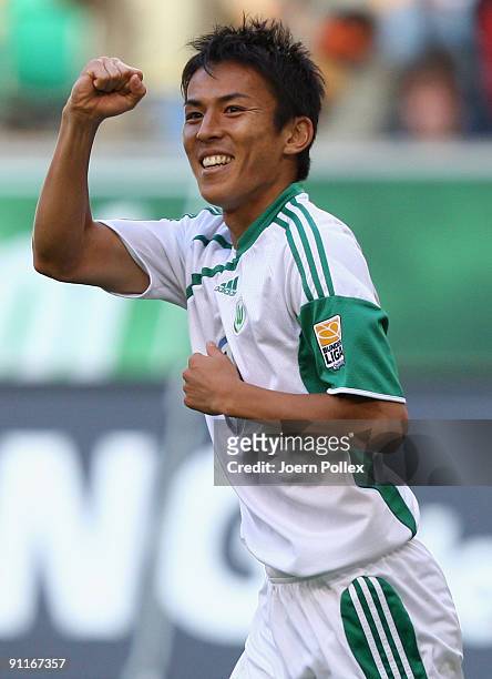 Makoto Hasebe of Wolfsburg celebrates after scoring his team's third goal during the Bundesliga match between VfL Wolfsburg and Hannover 96 at...