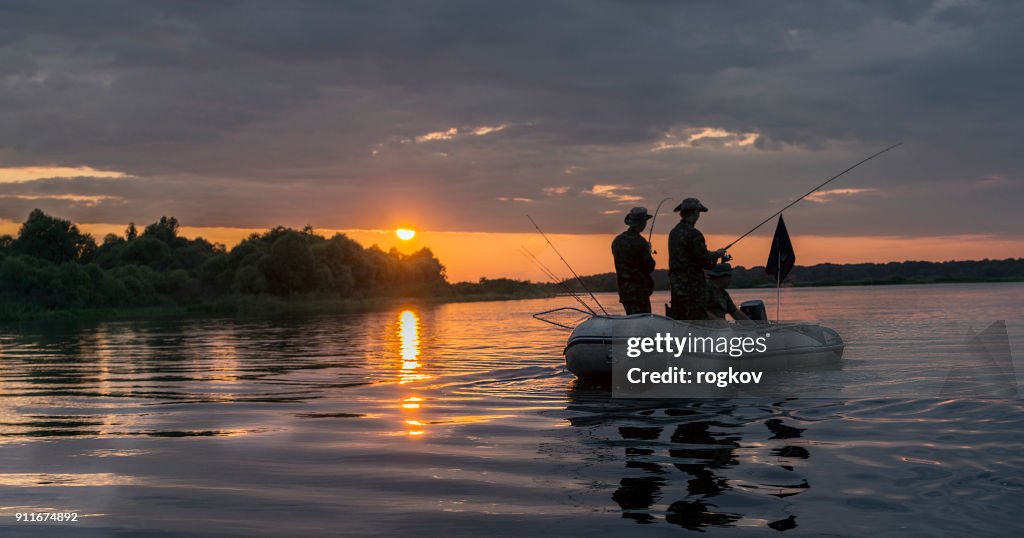 Mann in einem Boot am Sonnenuntergang Fisch.