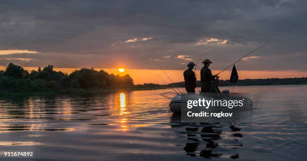 mann in einem boot am sonnenuntergang fisch. - bass fishing stock-fotos und bilder