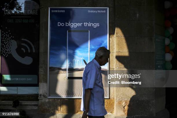 Pedestrian walks past an advert for Samsung Electronics Co. Galaxy Note 8 smartphone at a Croma electronic store, operated by Infiniti Retail Ltd.,...