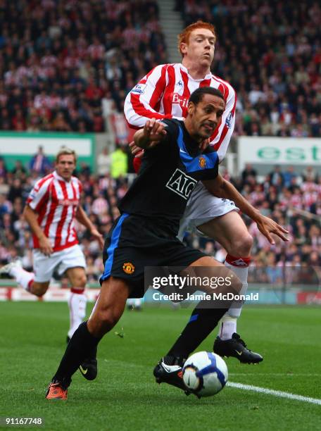 Rio Ferdinand of Manchester United holds off Dave Kitson of Stoke City during the Barclays Premier League match between Stoke City and Manchester...