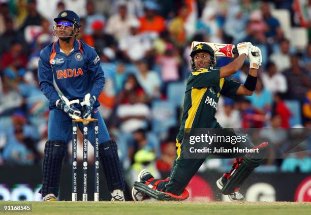 Mahendra Singh Dhoni of India watches on as Shoaib Malik hits out during The ICC Champions Trophy Group A Match between India and Pakistan on...