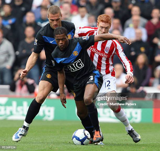 Patrice Evra of Manchester United clashes with Dave Kitson of Stoke City during the Barclays FA Premier League match between Stoke CIty and...