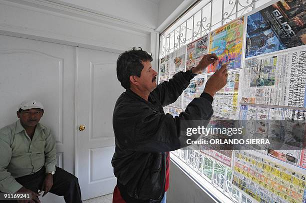 Supporter of ousted Honduran President Manuel Zelaya covers the windows of the Brazilian Embassy with newspapaer in Tegucigalpa, Honduras on...