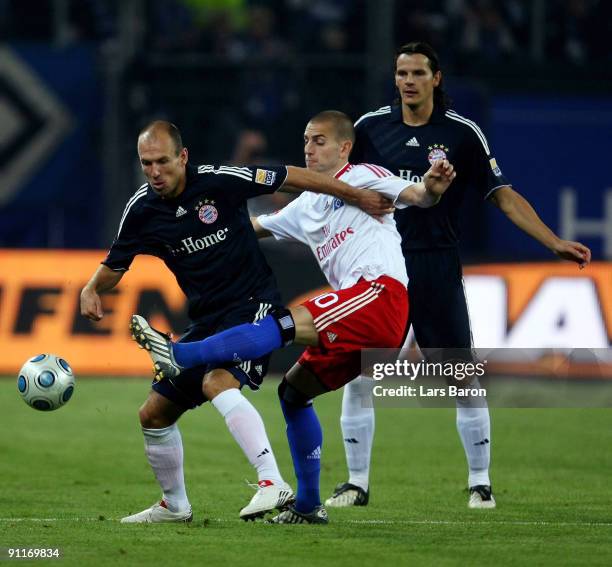 Arjen Robben of Muenchen is challenged by Mladen Petric of Hamburg next to Daniel van Buyten of Muenchen during the Bundesliga match between...