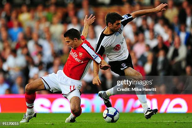 Aaron Hughes of Fulham battles for the ball with Robin Van Persie of Arsenal during the Barclays Premier League match between Fulham and Arsenal at...