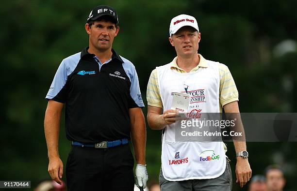 Padraig Harrington of Ireland converses with caddie Ronin Flood about his tee shot on the ninth hole during the third round of THE TOUR Championship...