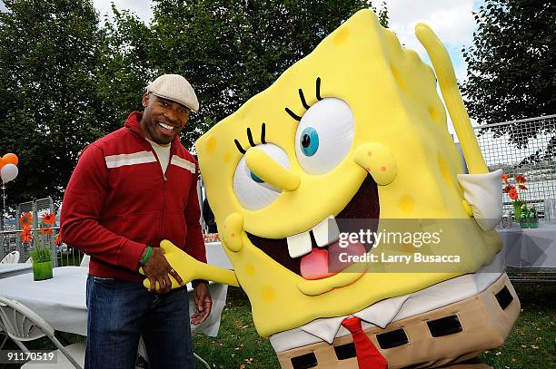 Former NFL player and TV personality Tiki Barber poses with Spongebob character backstage at Nickelodeon's Sixth Annual Worldwide Day of Play with...