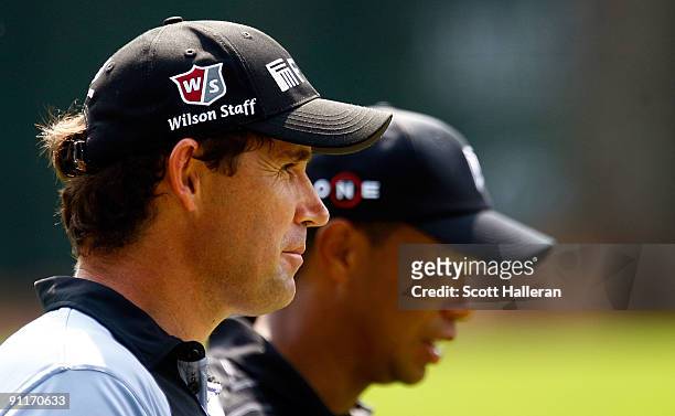 Padraig Harrington of Ireland walks alongside Tiger Woods on the 16th hole during the third round of THE TOUR Championship presented by Coca-Cola,...