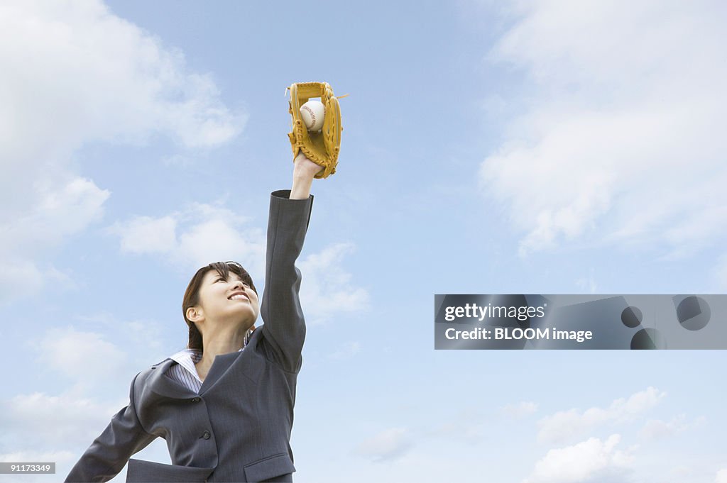 Businesswoman catching ball