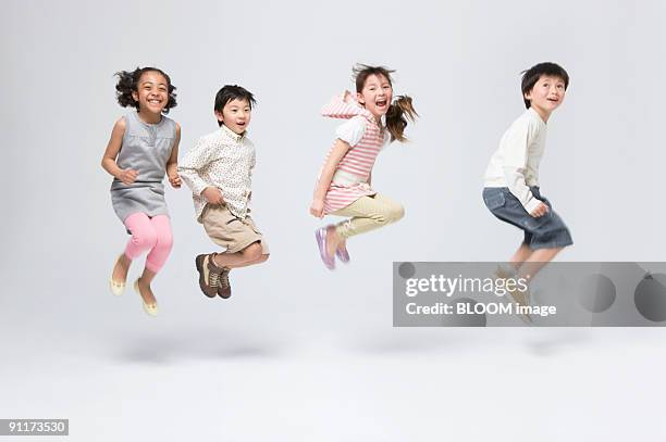 children jumping, studio shot - jumping casual clothing studio shot stock-fotos und bilder