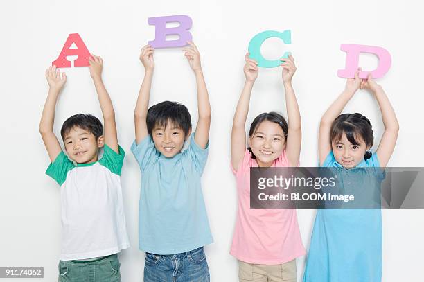 boys and girls holding alphabet mats - 日本人　英語 ストックフォトと画像