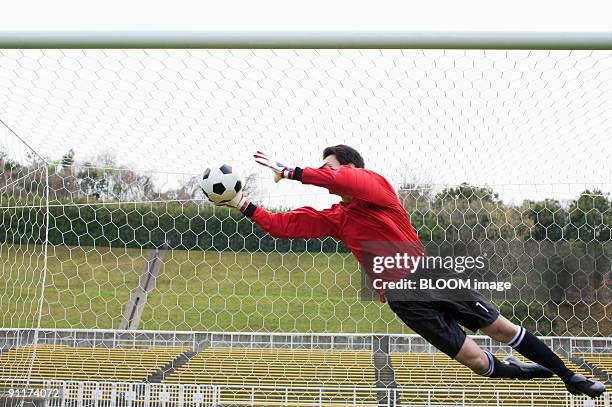 goalkeeper jumping for ball - goalie ストックフォトと画像