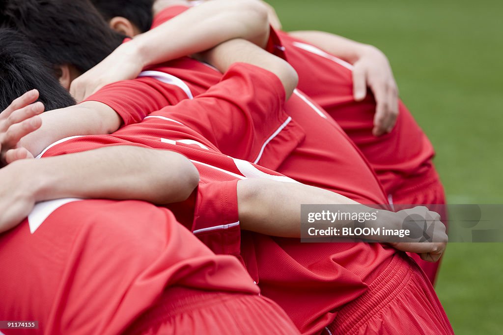 Soccer players with arms around each other