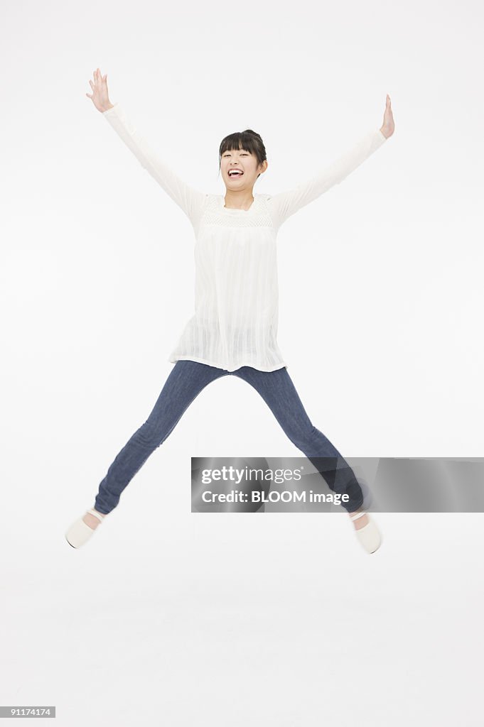 Young woman jumping, raising hands