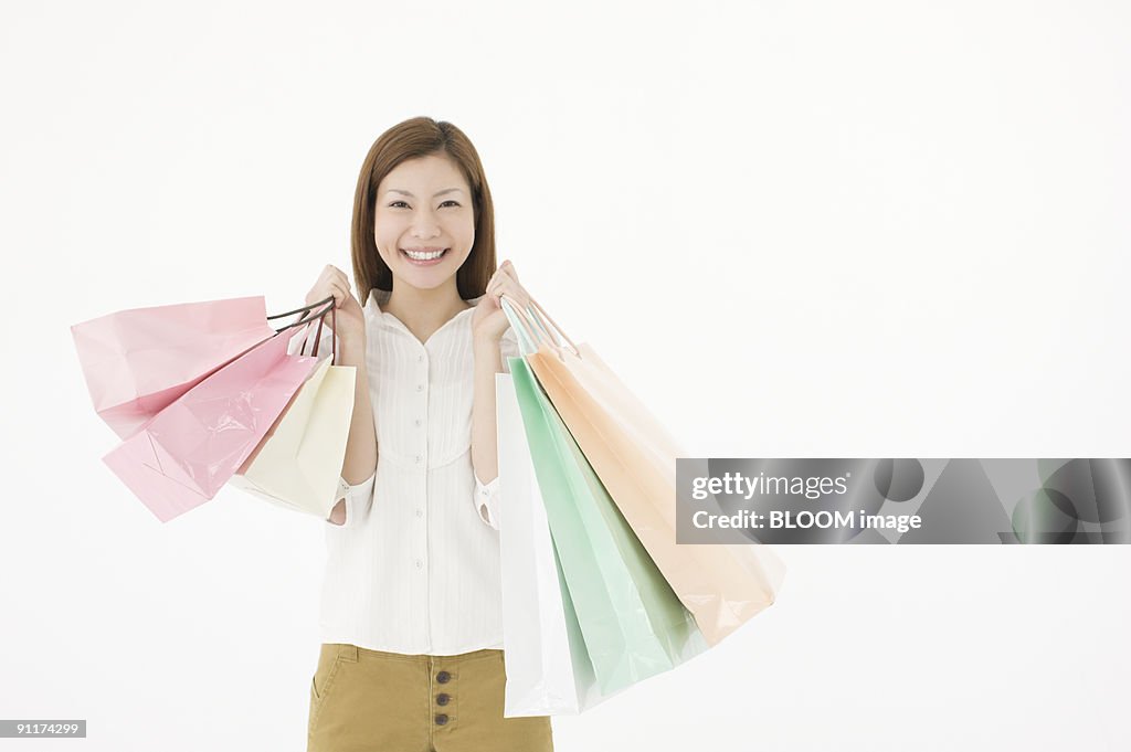 Woman holding shopping bags, smiling