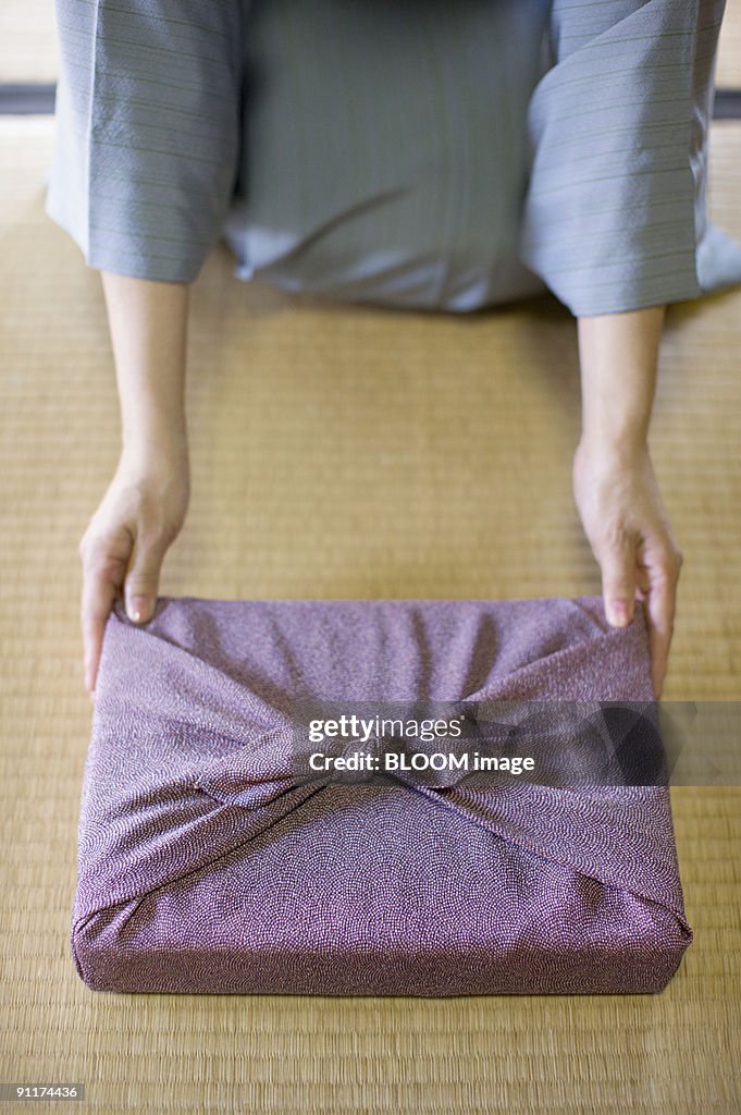 Woman in kimono holding out gift