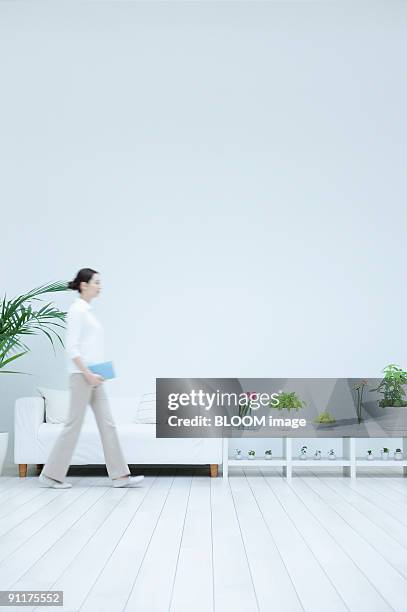 woman walking in living room, blurred motion - blurry living room stockfoto's en -beelden