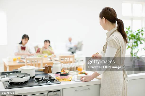 middle-aged woman preparing lunch box for family - schürze mann rückansicht stock-fotos und bilder