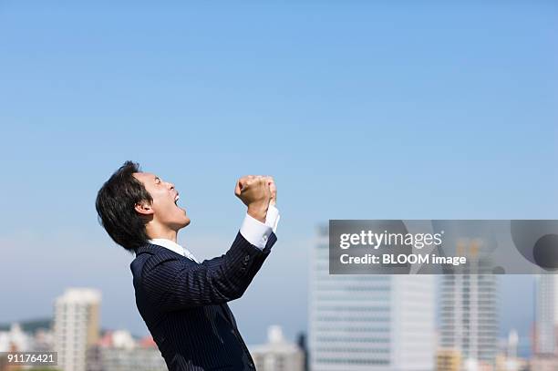 businessman shouting, clenching fists, side view - screaming man looking up stock-fotos und bilder