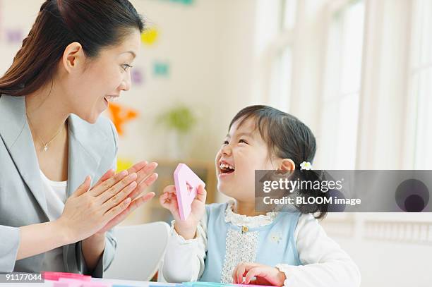 woman and girl playing with alphabet mats - 日本人　英語 ストックフォトと画像