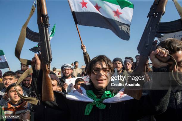 Syrians hold flags during a support rally for 'Operation Olive Branch' to Afrin after the Turkish military secure Burseya mountain within the...