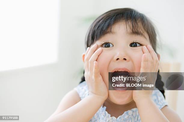 girl with hands on cheeks and mouth open - サプライズ ストックフォトと画像