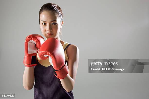 young woman wearing boxing gloves - boxing womens stock-fotos und bilder