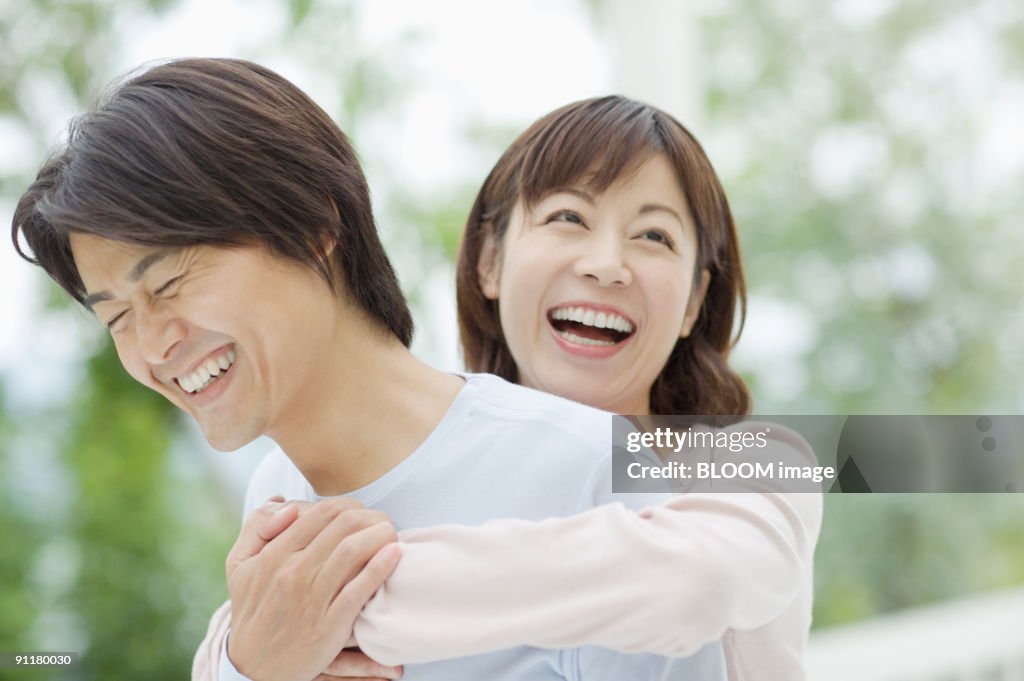 Woman holding man from behind