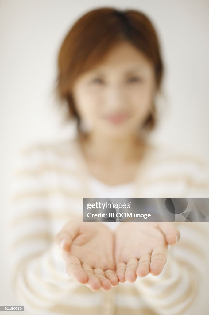 Woman holding out hands, focus on foreground