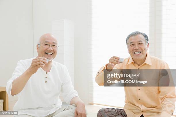 senior men having sake - copo de saké - fotografias e filmes do acervo