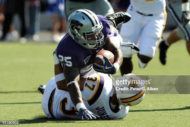 Running back Keithen Valentine of the Kansas State Wildcats dives over free safety Marty Jones of the Tennessee Tech Golden Eagles on a first down...