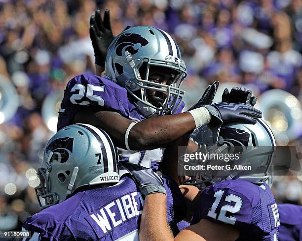 Running back Keithen Valentine of the Kansas State Wildcats celebrates after scoring a touchdown with teammates Collin Klein and Wade Weibert against...