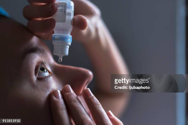 closeup of eyedropper putting liquid into open eye - eyedropper stock pictures, royalty-free photos & images