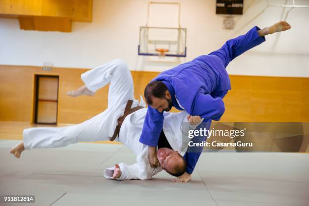 judoist fighters concurreren in judo wedstrijd - asian indoor & martial arts games stockfoto's en -beelden