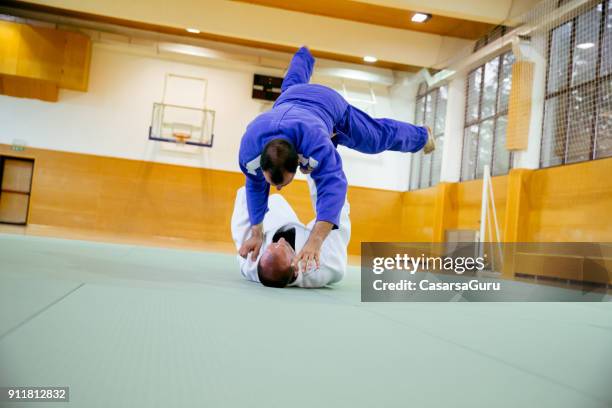 judoist fighters concurreren in judo wedstrijd - asian indoor & martial arts games stockfoto's en -beelden